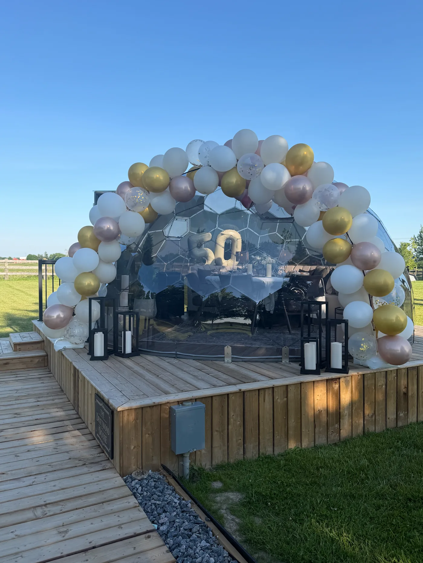 Dome dressed with a gold and white balloon arch for a celebration