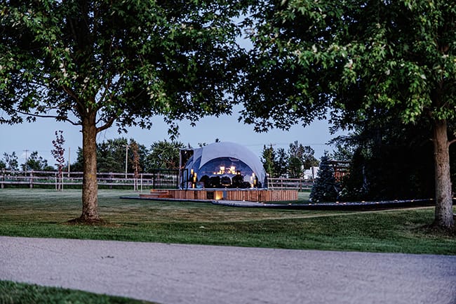 The dome glowing at dusk on the estate lawn
